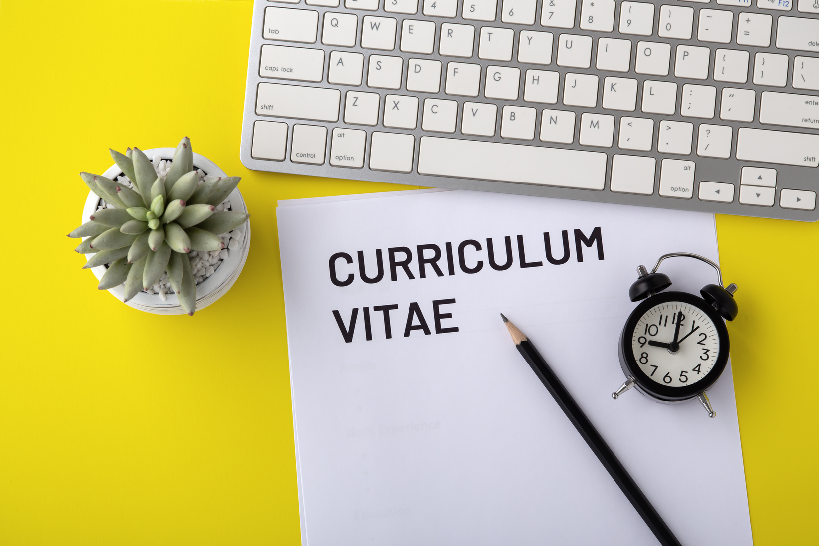 CV with keyboard and clock on yellow background